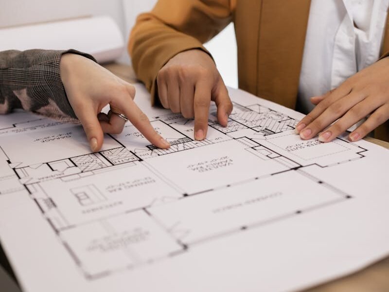 Two professionals discussing architectural plans in an office setting.